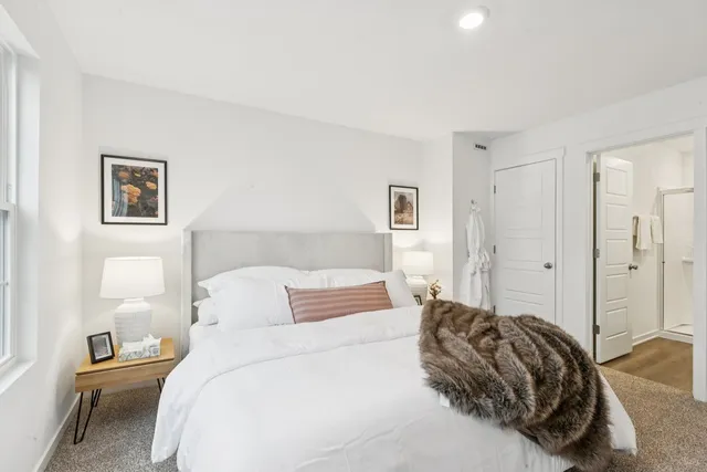 a bedroom with a bed and a painting on the wall