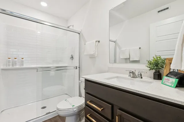 a bathroom with a sink a toilet and shower