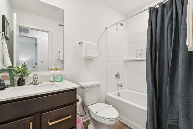 a bathroom with a sink a toilet a mirror and shower