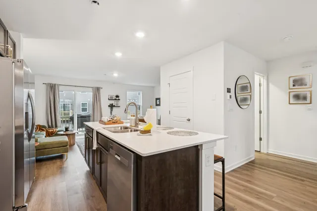a view of a kitchen counter space a sink wooden floor and a window