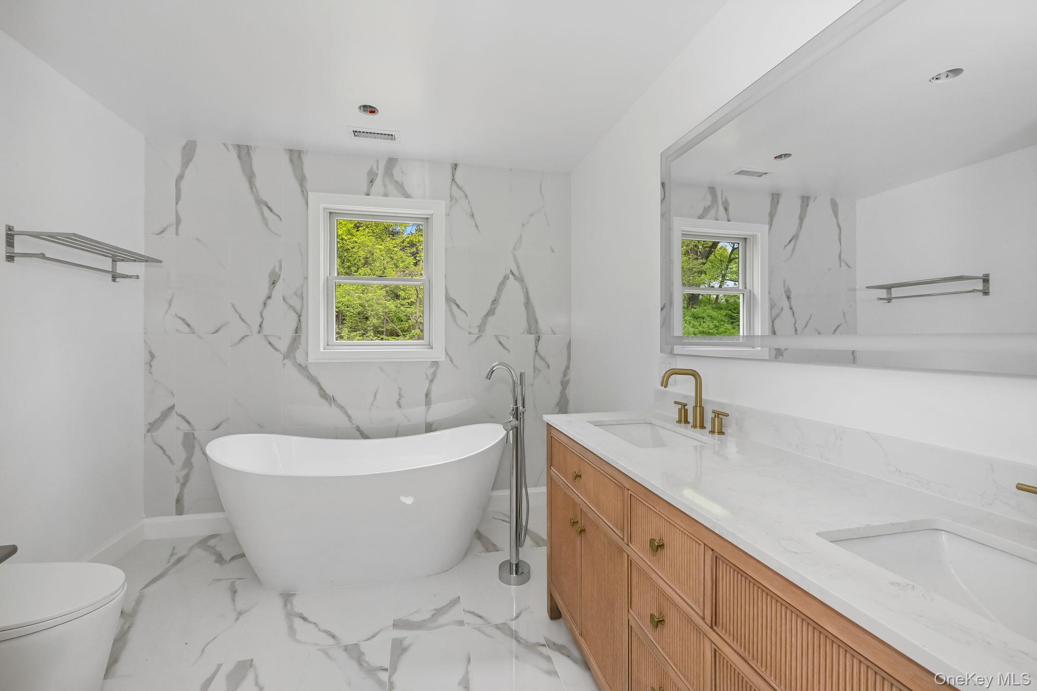 24 Country Road Mamaroneck, NY 10543 - Photo 15 of 37 a spacious bathroom with a bathtub sink and toilet