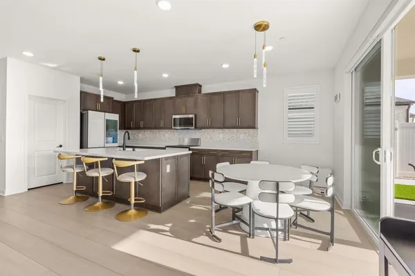 a kitchen with stainless steel appliances granite countertop a sink and a stove top oven with wooden floor