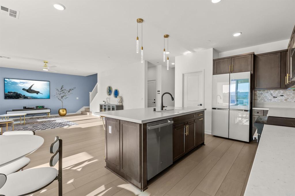 550 Meadowood Street Fallbrook, CA 92028 - Photo 11 of 37 a kitchen with white cabinets and stainless steel appliances