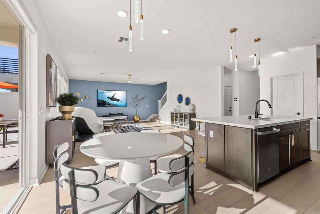 550 Meadowood Street Fallbrook, CA 92028 - Photo 12 of 37 a kitchen with granite countertop a sink chairs and white cabinets