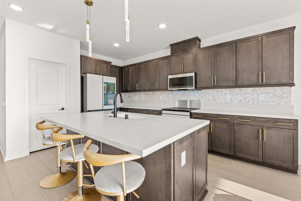 550 Meadowood Street Fallbrook, CA 92028 - Photo 8 of 37 a kitchen with kitchen island a sink stove and microwave