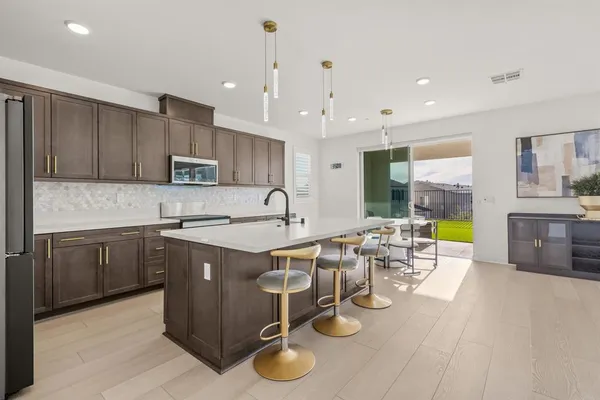 a kitchen with a dining table chairs and white appliances