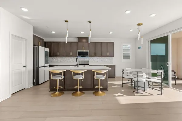 a kitchen with kitchen island a sink stove and microwave
