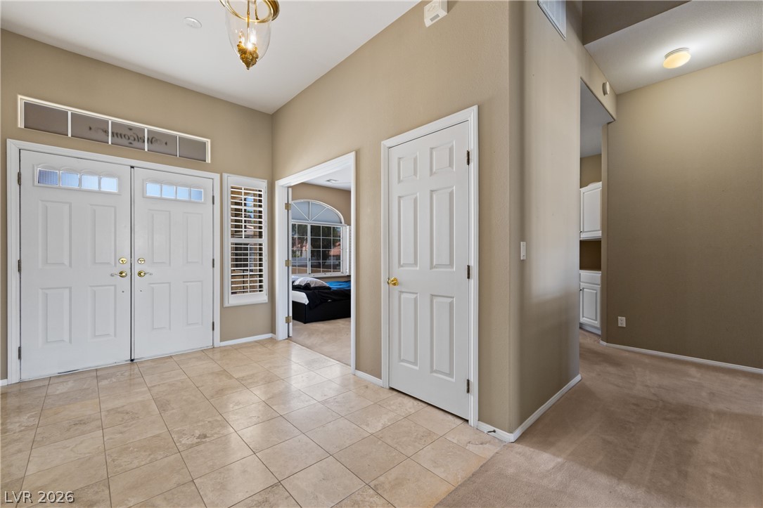 649 Rancho Circle Mesquite, NV 89027 - Photo 14 of 73 Step inside this inviting entry, where tiled flooring transitions to plush carpeting, creating a seamless flow.