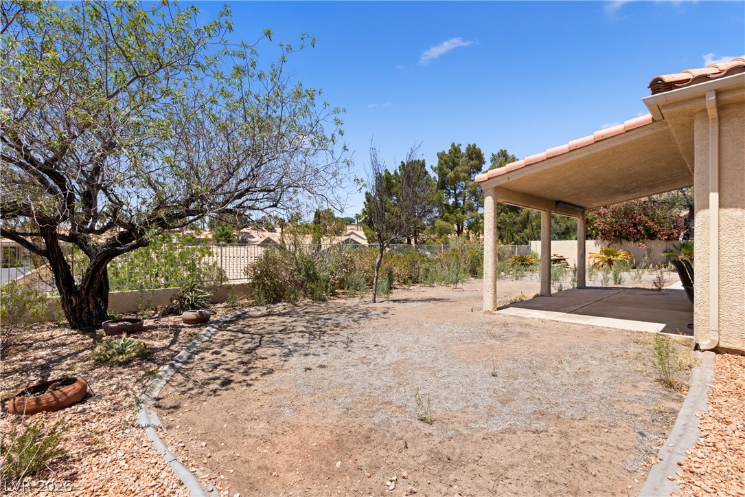 649 Rancho Circle Mesquite, NV 89027 - Photo 44 of 73 This spacious yard offers a blank canvas for outdoor living, featuring a covered patio and mature trees.