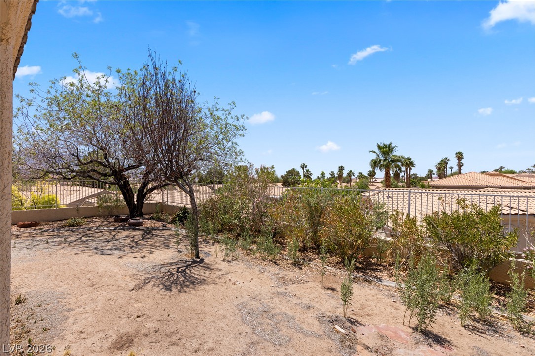649 Rancho Circle Mesquite, NV 89027 - Photo 47 of 73 This spacious yard offers natural landscaping and distant palm tree views under a bright sky.