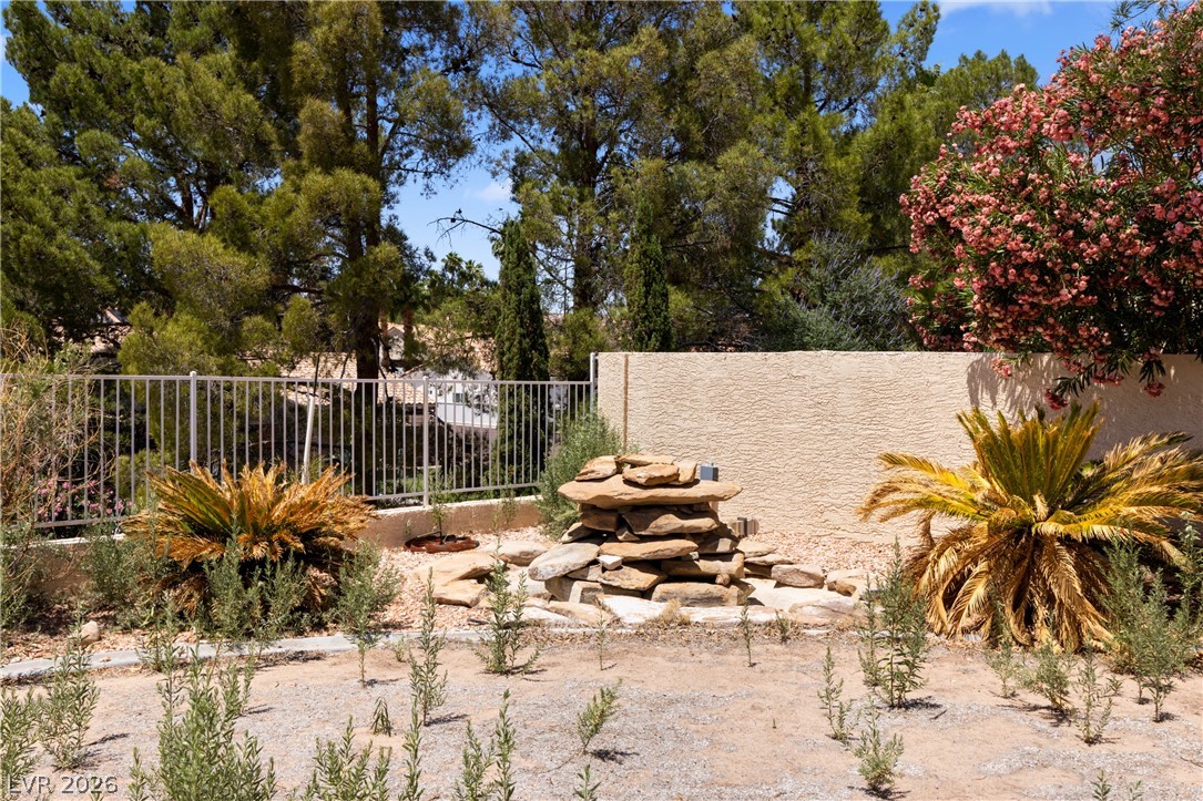 649 Rancho Circle Mesquite, NV 89027 - Photo 56 of 73 This spacious backyard features a rock fountain and mature trees, perfect for outdoor enjoyment.