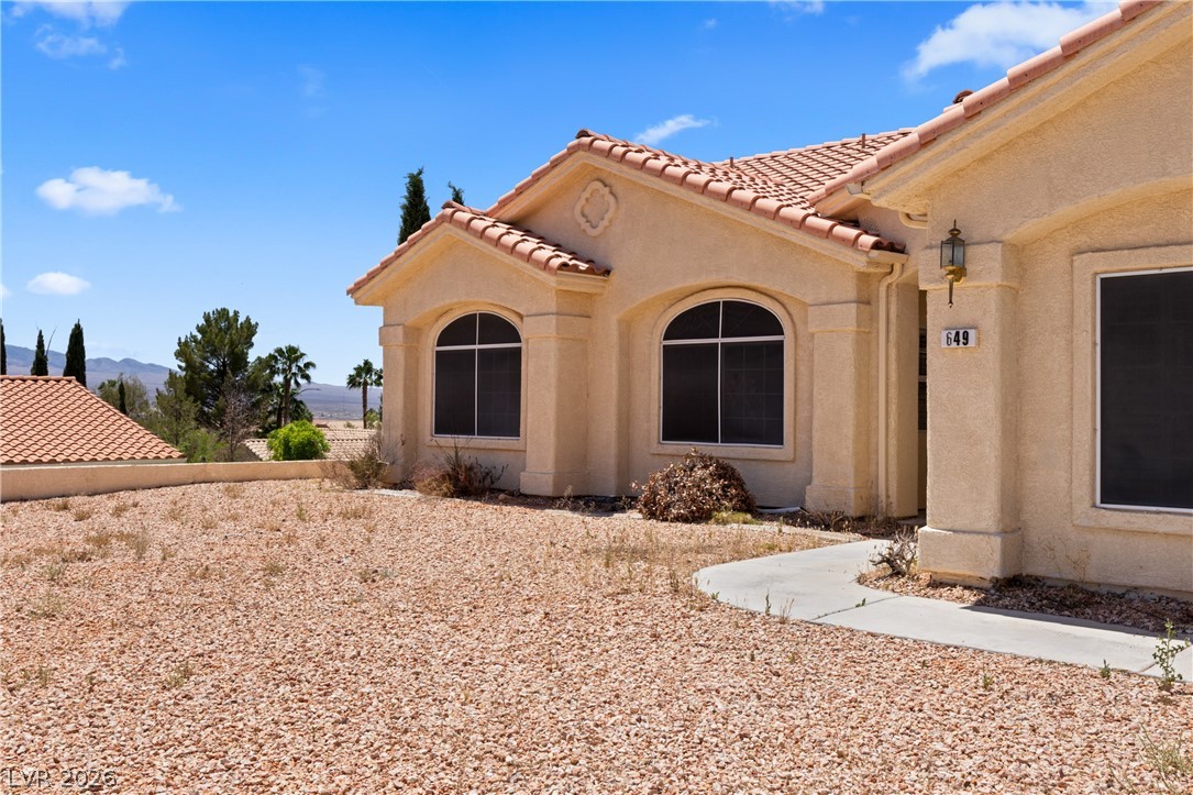 649 Rancho Circle Mesquite, NV 89027 - Photo 59 of 73 This desert oasis features a classic stucco exterior and a vibrant tile roof, offering charming curb appeal.