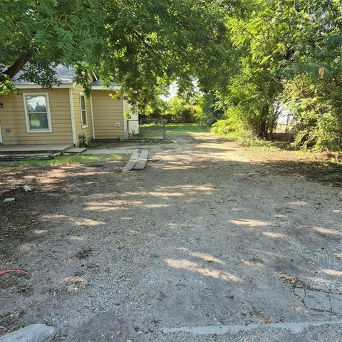 a view of a backyard with large trees