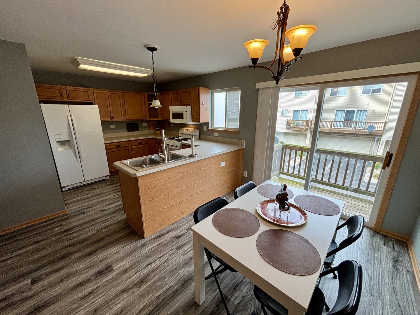 906 Clover Lane, Unit 906 Pingree Grove, IL 60140 - Photo 6 of 37 a view of a dining room with furniture wooden floor and chandelier