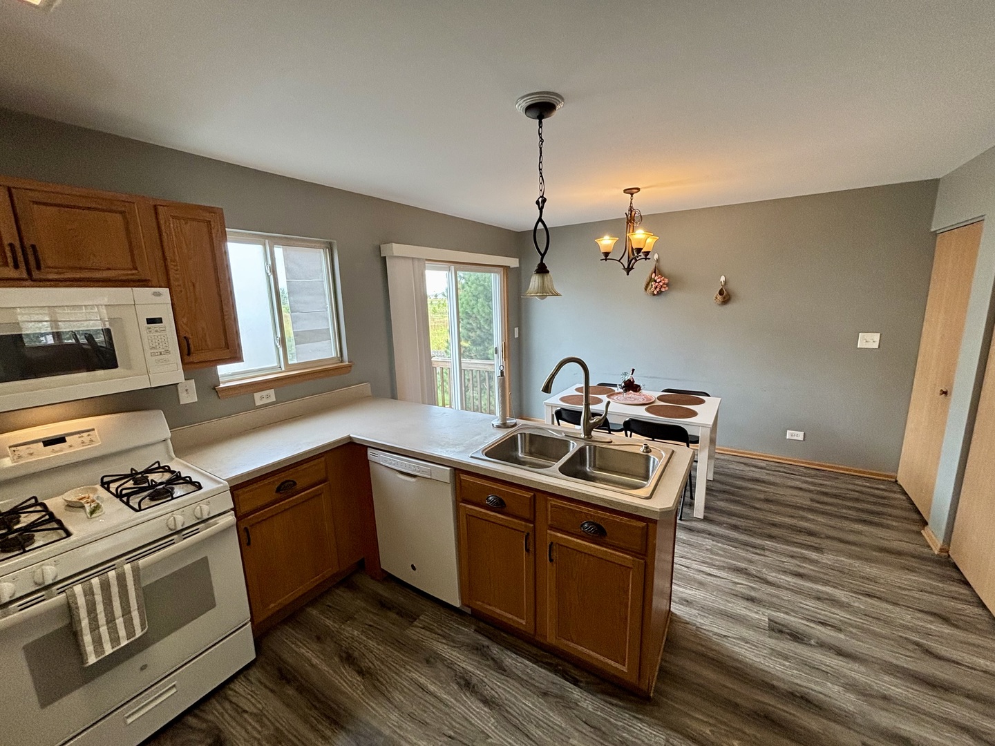 906 Clover Lane, Unit 906 Pingree Grove, IL 60140 - Photo 8 of 37 a kitchen with stainless steel appliances granite countertop a sink stove and wooden floor