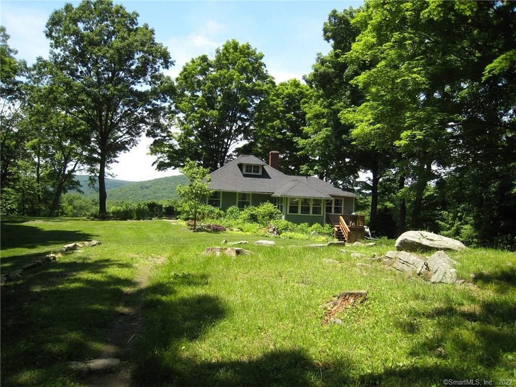 25 Cherry Hill Road Cornwall, CT 06796 - Photo 1 of 1 a backyard of a house with table and chairs plants and large tree