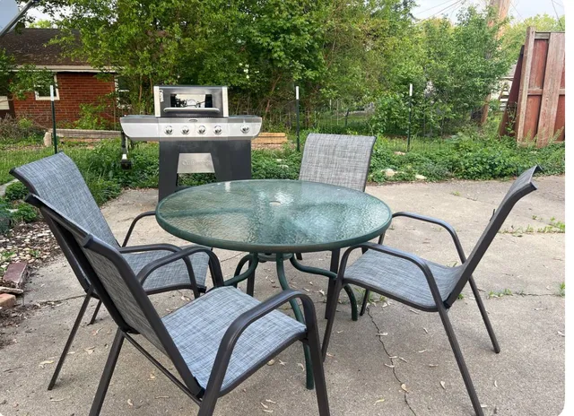 a backyard of a house with table and chairs