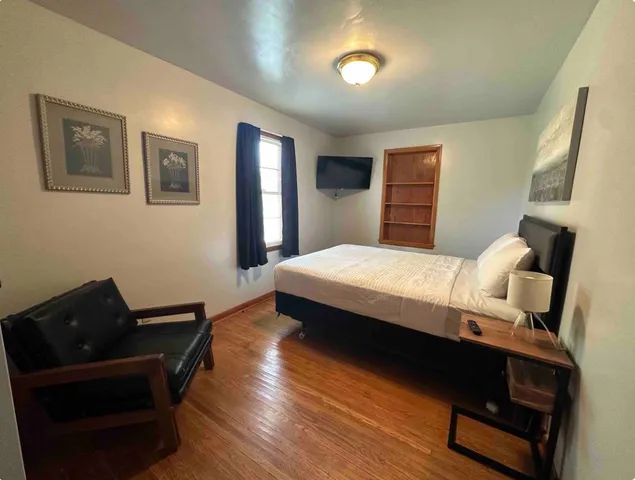 a bedroom with a bed and wooden floor