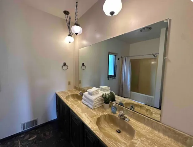 a bathroom with a granite countertop sink a mirror and vanity