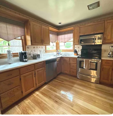 a kitchen with stainless steel appliances kitchen island granite countertop a sink and cabinets