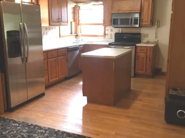 a kitchen with stainless steel appliances granite countertop a refrigerator a sink a stove and island