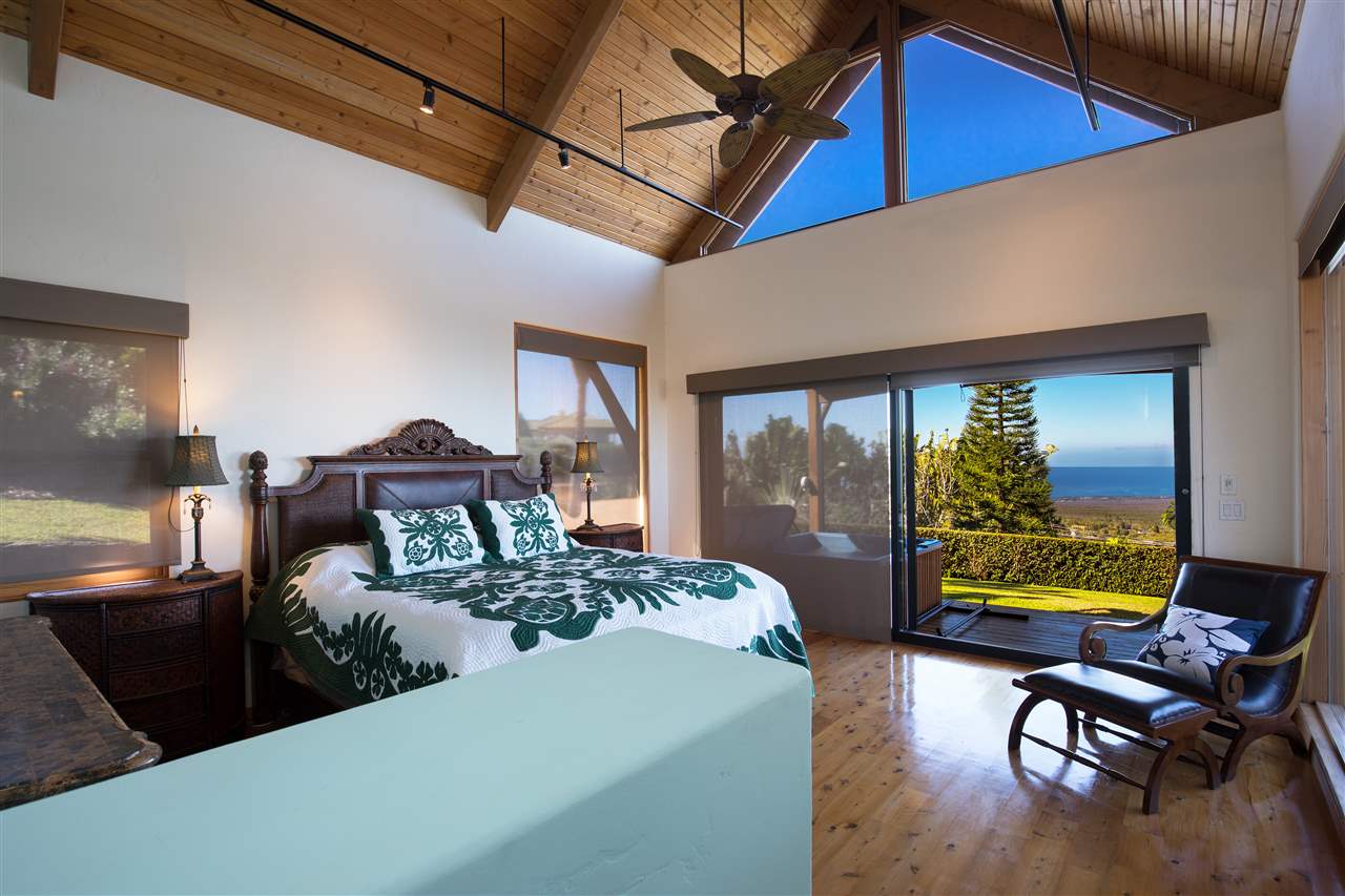2623 Lower Kula Road Kula, HI 96790 - Photo 11 of 29 a bedroom with a bed and wooden floor