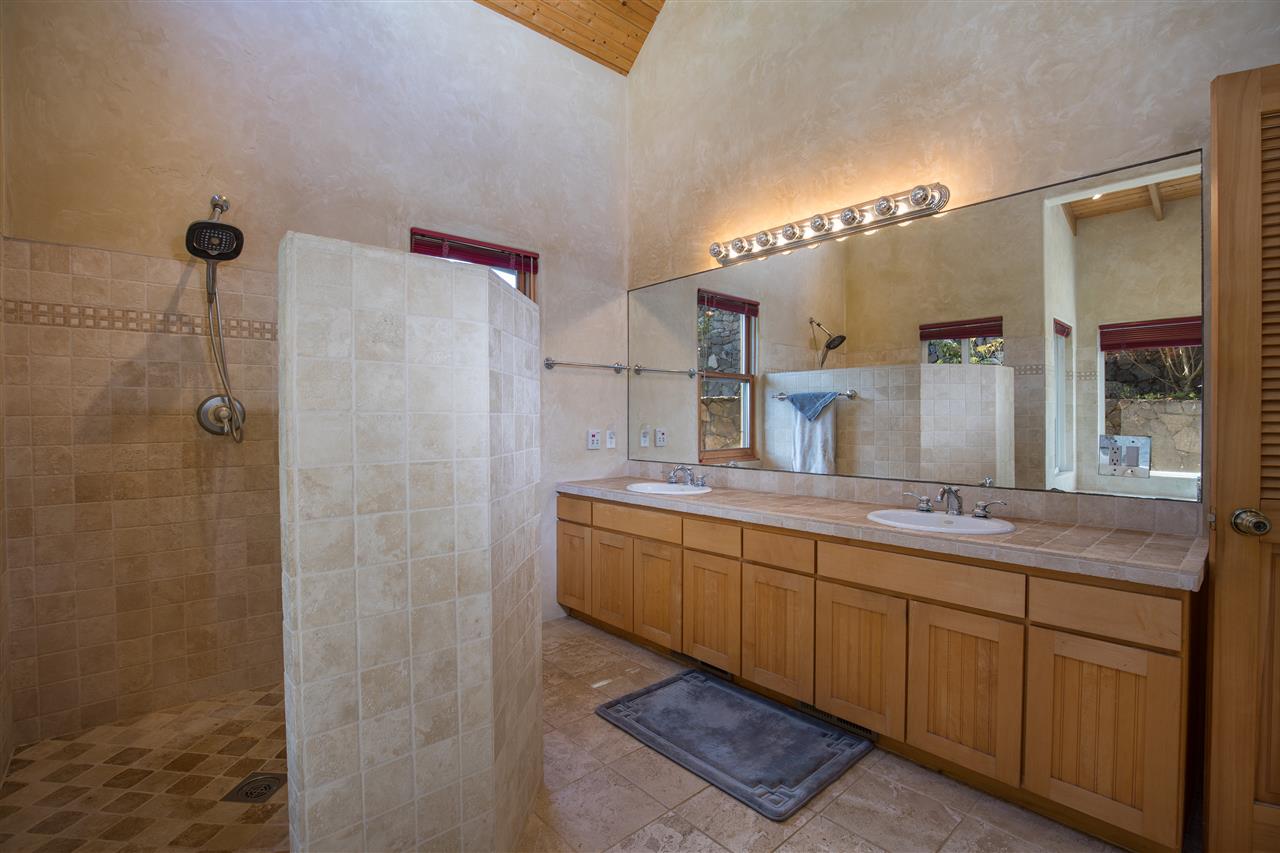 2623 Lower Kula Road Kula, HI 96790 - Photo 14 of 29 a bathroom with a granite countertop sink a mirror and a shower