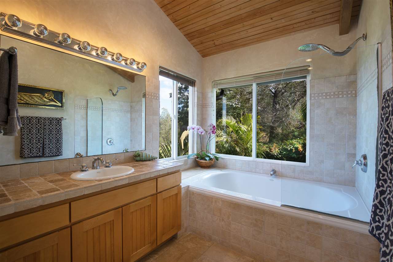 2623 Lower Kula Road Kula, HI 96790 - Photo 21 of 29 a bathroom with a granite countertop tub sink and mirror