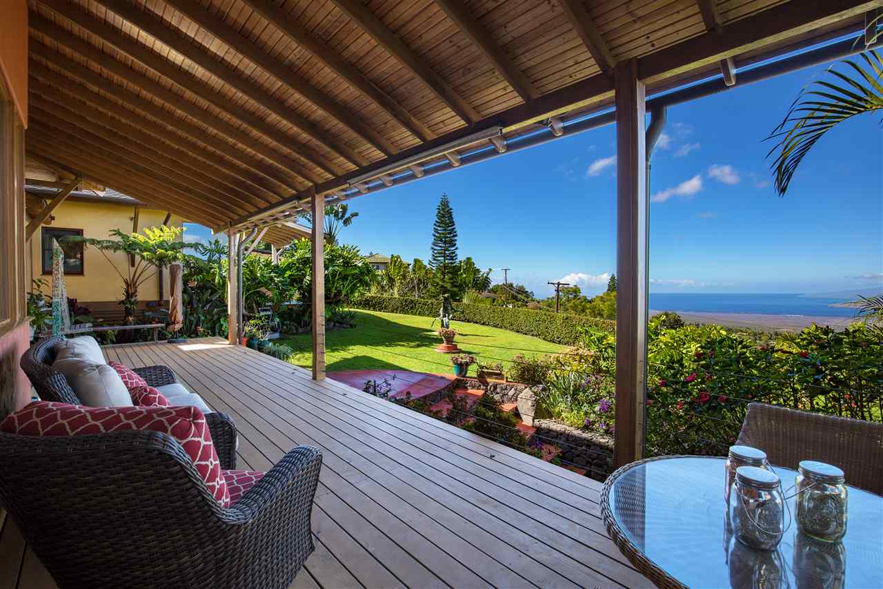 2623 Lower Kula Road Kula, HI 96790 - Photo 8 of 29 a view of a patio with table and chairs potted plants with wooden floor and fence