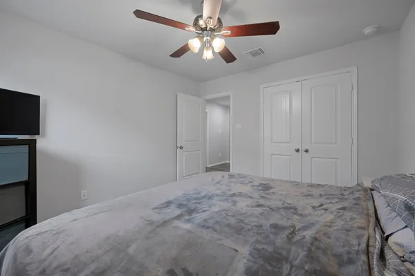 a bedroom with a bed and a ceiling fan