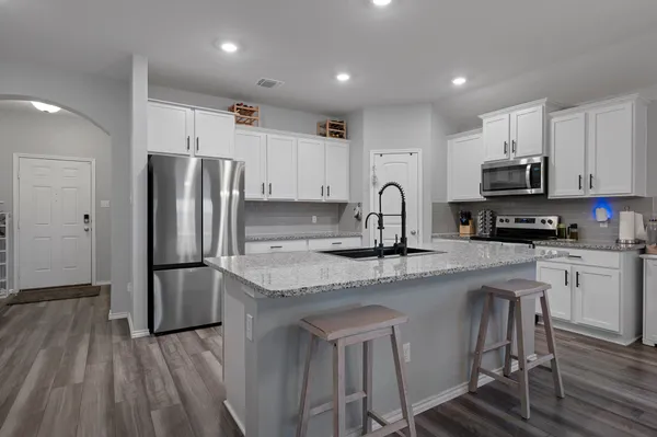a kitchen with appliances a sink and cabinets