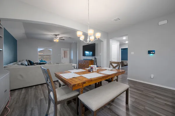a kitchen with a dining table chairs refrigerator and cabinets