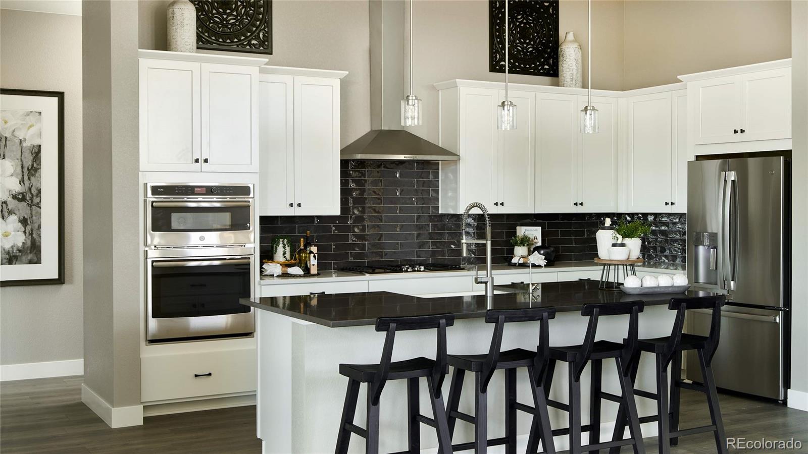3867 Freestone Point Castle Rock, CO 80108 - Photo 10 of 38 a kitchen with stainless steel appliances granite countertop a stove a refrigerator a sink a stove and white cabinets