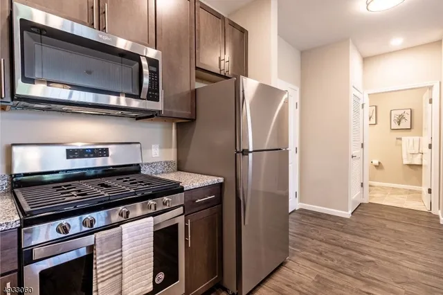 a kitchen with stainless steel appliances granite countertop a refrigerator stove and microwave
