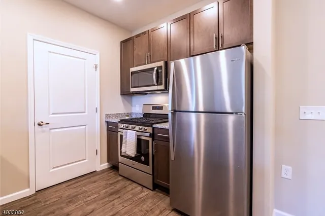 a metallic refrigerator freezer sitting in a kitchen