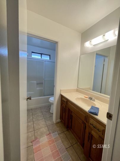 200 North American Street Ridgecrest, CA 93555 - Photo 12 of 23 a bathroom with a granite countertop sink a toilet and shower