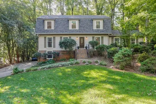 a front view of a house with a yard and outdoor seating