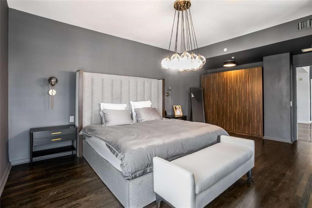 3475 Oak Valley Road Northeast, Unit 1630 Atlanta, GA 30326 - Photo 29 of 38 a spacious bedroom with a bed and a chandelier