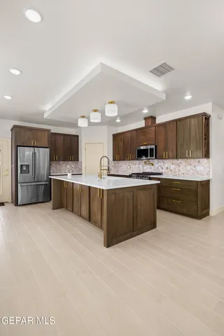a kitchen with stainless steel appliances granite countertop a stove and cabinets