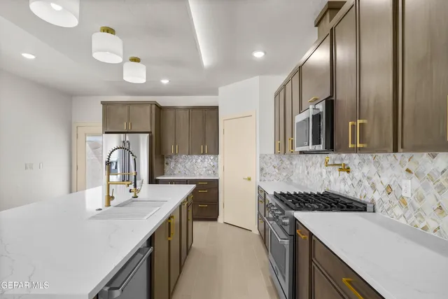 a kitchen with a stove a sink and a refrigerator