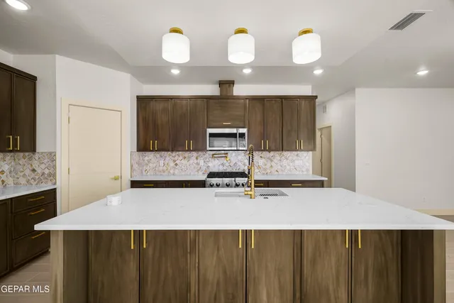 a large kitchen with a large counter top appliances and cabinets