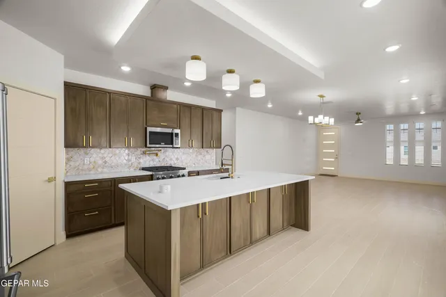 a kitchen with stainless steel appliances granite countertop a sink and a stove