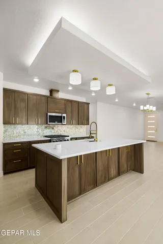 a kitchen with stainless steel appliances a sink stove and cabinets