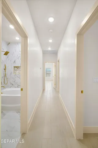 a bathroom with a granite countertop sink a toilet a mirror and bathtub