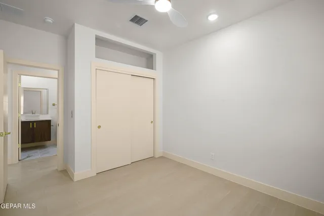 an empty room with a window and a ceiling fan