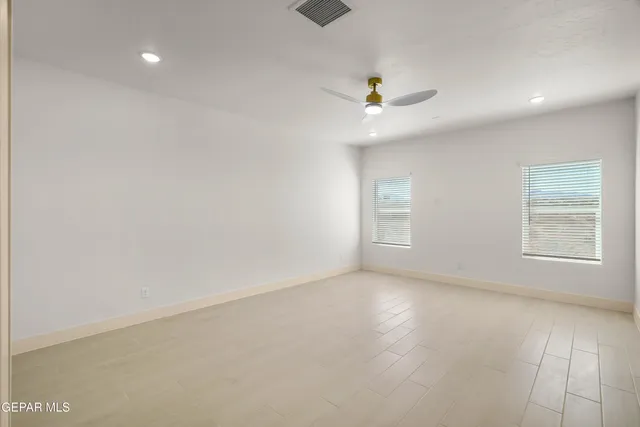 an empty room with an entryway and kitchen