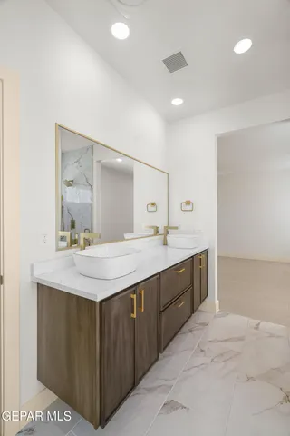 a spacious bathroom with a granite countertop sink a toilet and a mirror