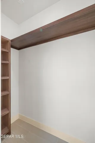 a view of walk in closet with empty racks