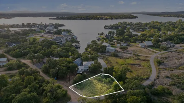 an aerial view of a house with a yard and lake view