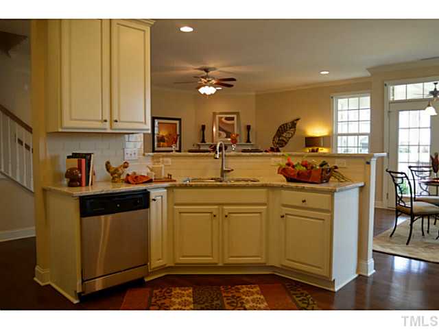 804 Chapanoke Road Raleigh, NC 27603 - Photo 12 of 25 a kitchen with kitchen island granite countertop a sink cabinets and wooden floor